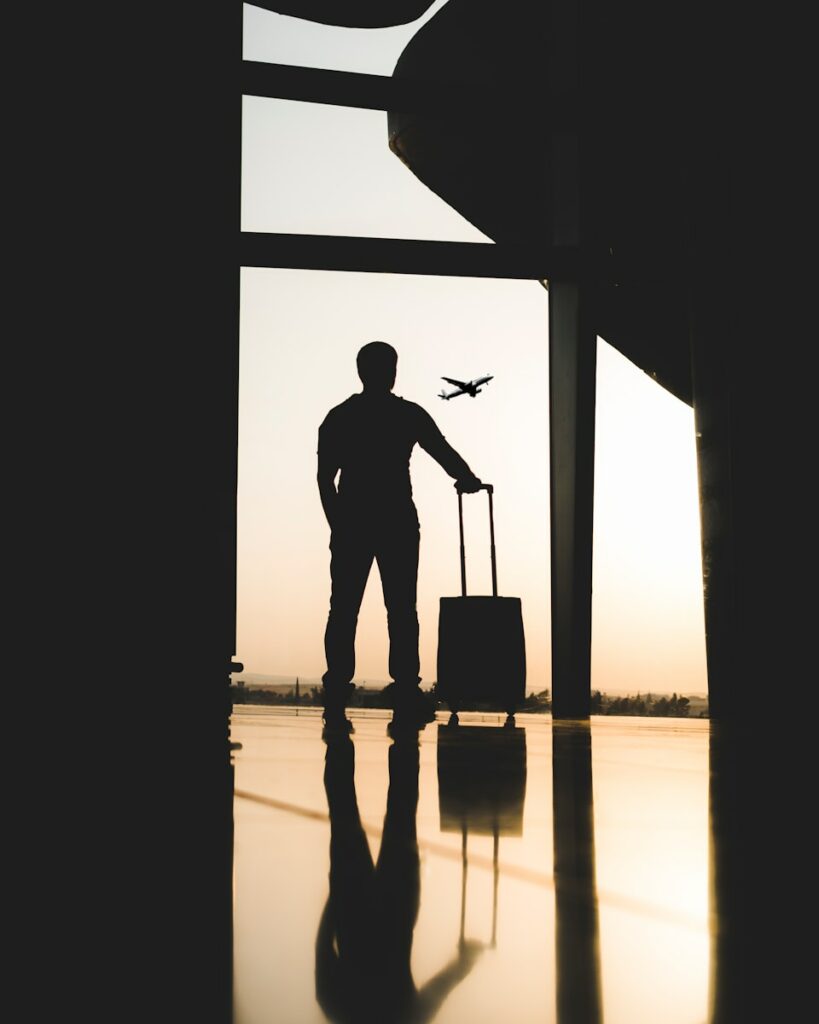 Avoid Getting Bumped From a Flight silhouette of man holding luggage inside airport